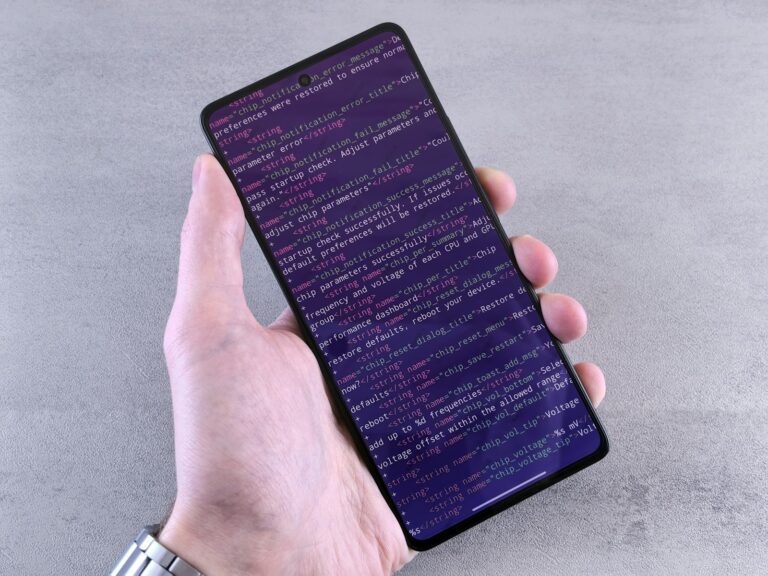 Hand holding phone authenticator app closeup code computer
