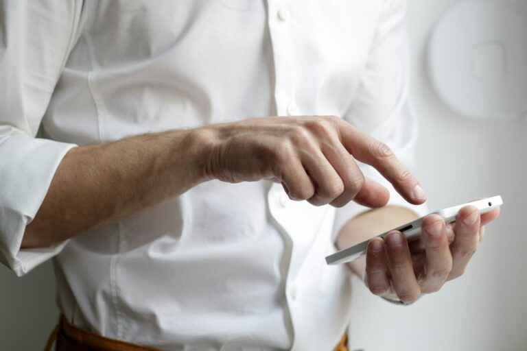 Closeup authenticator app smartphone person writing backup codes
